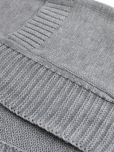Macro shot of grey knitted sweater showing high-quality fiber texture and ribbing detail