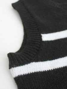 Detailed close-up of rib-knit crewneck and black striped pattern on a sleeveless sweater