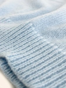Détail de la maille du débardeur en tricot bleu clair et finition bord-côte
