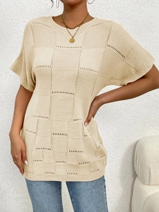 Close-up of beige knit top featuring vintage hollow check pattern and round neckline