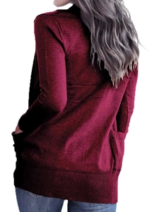 Detail of dark red knit cardigan back featuring rib-knit hem and large side pockets
