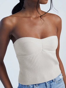 Women's cream ribbed knit tube top paired with denim jeans for a summer beach vacation style