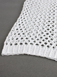 White long sleeve crochet knit sweater featuring hollow mesh patterns and ribbed hem detail
