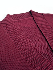Detailed close-up of the burgundy knit cardigan featuring ribbed collar and fine texture