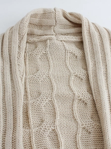 Chunky cable knit cardigan in beige featuring a classic shawl collar and textured pattern
