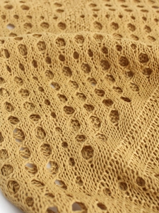 Vue macro détaillée du tissu en maille pointelle jaune gingembre montrant la texture ajourée