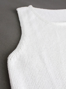 Women's minimalist white sleeveless knit top with high round neck and soft texture