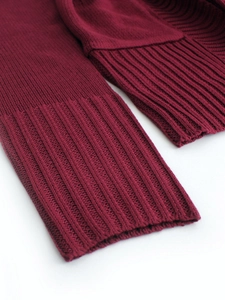 Close-up of wine red knitted cardigan showing detailed ribbed cuffs and texture