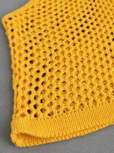 Close-up of vibrant yellow crochet knit fabric with detailed mesh texture and ribbed edges