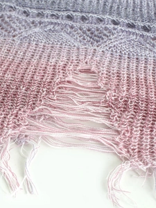 Détail rapproché d'un débardeur de plage en tricot avec dégradé violet et bords à franges