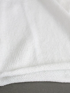 Women's white sleeveless knit sweater vest with delicate rolled hem and crew neck