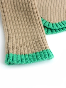 Détail de manche en maille côtelée kaki avec revers contrasté vert vif et finitions