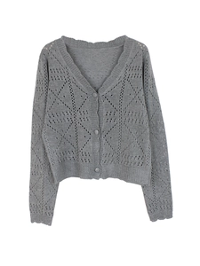 Detail of grey V-neck cardigan featuring hollow diamond knit pattern and rib-knit cuffs