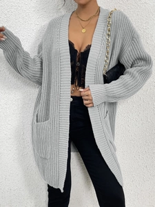 Detail of grey long sleeve knitted cardigan with large side pockets and ribbed texture