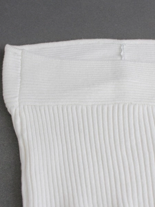 Close-up of white ribbed knit fabric texture on a summer crop top or beach vest