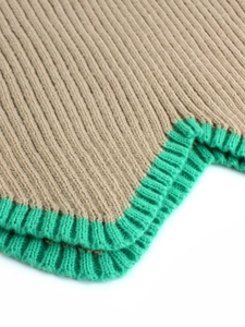 Gros plan détaillé sur la maille côtelée avec bordure contrastée beige et verte