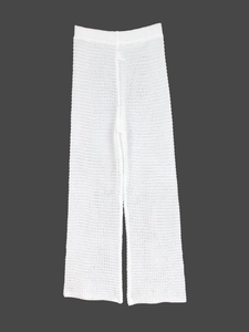 Detail of white crochet knit beach pants showing semi-transparent hollow texture and weave