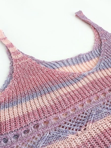 Gros plan sur tissu en maille rayée dégradée rose et violet avec détails ajourés
