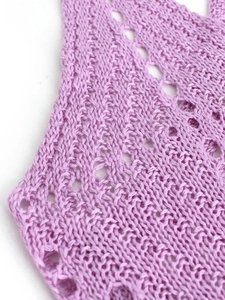 Gros plan sur le tissu en maille pointelle lavande avec motifs ajourés délicats