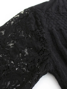 Detailansicht eines schwarzen Damenpullovers mit floralen Spitzeärmeln und Rippenstrick