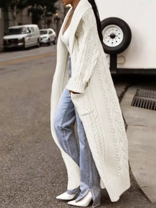 Side view of white cable knit long cardigan with shawl collar and side pockets