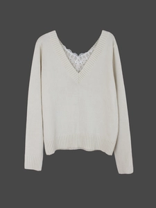 Detail of V-neck knitted sweater featuring delicate white lace trim and ribbed texture