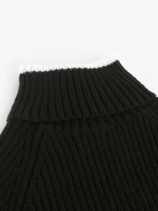 Détail du pull en maille côtelée noire avec col montant et bordure rayée blanche