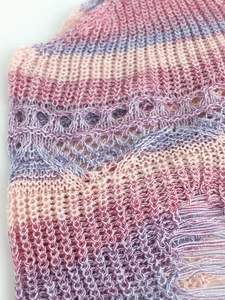 Détail du haut court en tricot avec dégradé pastel et finitions à franges au bas