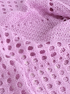 Détail du tissu en maille pointelle violet clair montrant des motifs ajourés