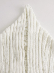 Close-up of white chunky knit sweater collar featuring detailed cable and ribbed textures