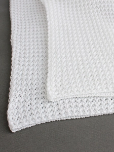 White knitted mesh beach trousers with intricate hollow-out texture and elegant drape