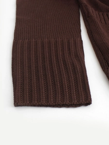 Close-up of the elastic ribbed cuff on a brown knitted cardigan sweater with fine texture