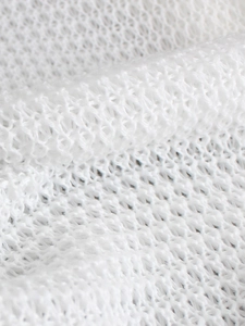 White hollow knit fabric detail showing texture and breathable mesh for beach trousers