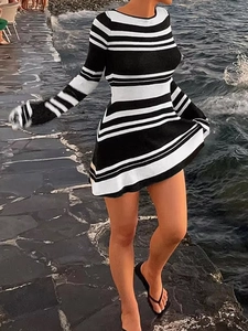 Outdoor shot of a black and white striped long-sleeve knit mini dress for women
