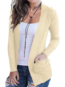 Detail of light yellow knit cardigan featuring ribbed cuffs and convenient side pockets