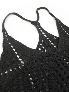 Détail d'un camisole au crochet noir présentant un motif floral ajouré et délicat