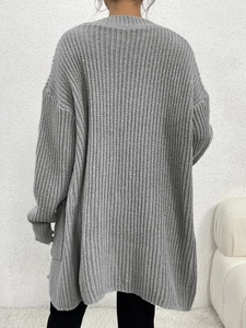 Detail view of the thick knit texture and ribbed cuffs on a long grey cardigan sweater