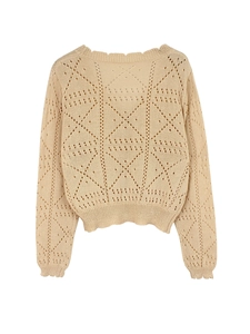 Detail of apricot pointelle knit sweater with diamond patterns and scalloped edges