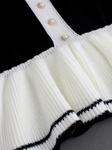 Robe pull élégante avec col contrasté, boutons perle et détail de jupe plissée
