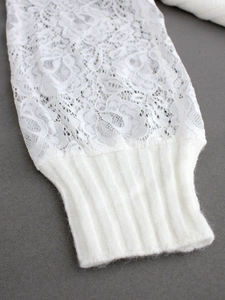 Detaillierte Nahaufnahme von weißen floralen Spitzenärmeln und elastischen Strickbündchen