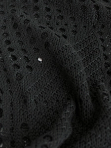 Gros plan détaillé sur la texture du tricot noir au crochet et le design ajouré
