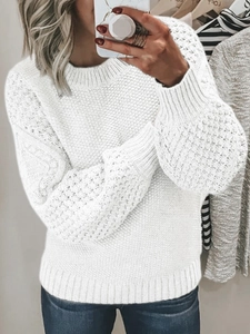 Close-up of white popcorn knit sweater featuring ribbed crew neck and textured fabric