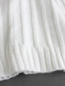 Detaillierte Makroansicht der weißen Rippstrick-Struktur eines eleganten Damenpullovers