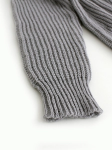 Close-up of grey knit cardigan featuring soft rib-knit cuffs and textured wool fabric