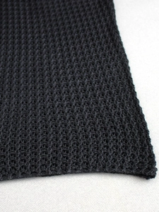 Close-up of black mesh knit fabric with hollow texture and breathable grid pattern
