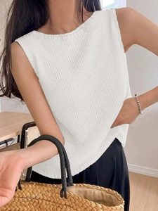 Detailed close-up of white chunky knit sleeveless vest texture and round neckline style