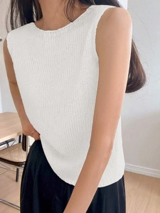 Detail of white knit sleeveless vest with crew neck showing slim fit and fine texture