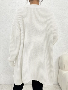 Close-up showing white chunky knit texture and ribbed cuffs of long sleeve cardigan