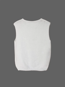 Close-up of white knitted vest showing detailed fine-knit texture and ribbed hem detail