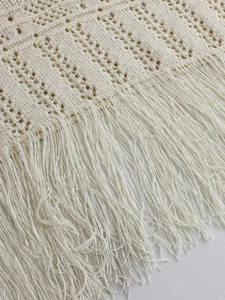 Women's cream knit midi skirt featuring hollow crochet patterns and fringe hem detailing